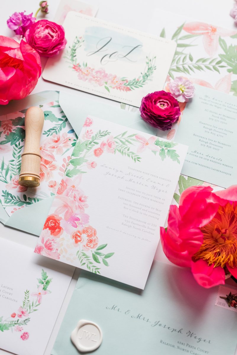Floral watercolor wedding stationery and invitations for a spring wedding in downtown Raleigh, North Carolina, at the event venue The Stockroom at 230 and The Glass Box. Their photographer, Mikkel Paige Photography, captured this lay flat of their hot pink and aqua blue invitation by @OneandOnlyPaper. #MikkelPaige #DowntownRaleigh #RaleighWedding #RaleighVenue #TheStockroomat230 #floralwatercolorinvitation #weddinginvitation #peonyweddinginspiration #oopaper #oneandonlypaper #layflatphotography