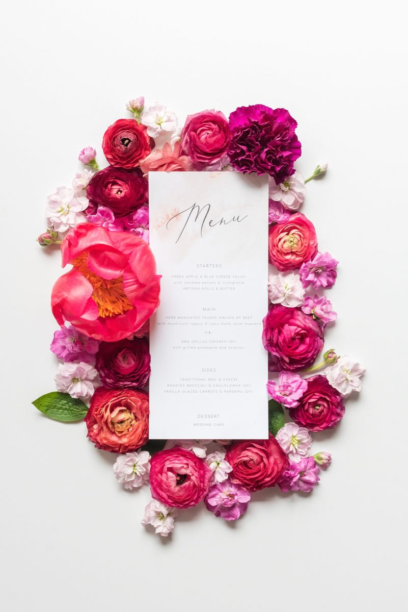 A beautiful spring wedding in downtown Raleigh, North Carolina, at the event venue The Stockroom at 230. Mikkel Paige Photography, their photographer, captured a lay flat of their menu from the reception, with hot pink and aqua blue watercolors and flower detail. #MikkelPaige #DowntownRaleigh #RaleighWedding #RaleighVenue #TheStockroomat230 #weddingreception #weddingmenu #layflatphotography