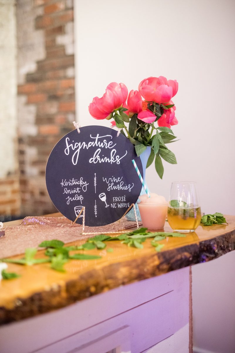 Frose, wine slushes and Mint Julips from Kentucky were a highlight and signature drinks of a spring wedding downtown Raleigh, North Carolina, at the event venue The Stockroom at 230 with hot pink and aqua details and colors. Mikkel Paige Photography, their photographer, captured the celebration. #MikkelPaige #DowntownRaleigh #RaleighWedding #RaleighVenue #TheStockroomat230 #weddingreception #weddingmenu #weddingcake #frose #wineslushies #adultslushies #mintjulips