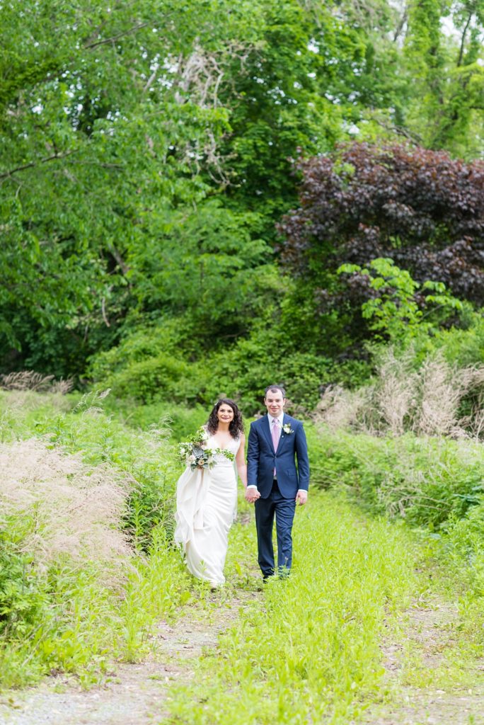 Westchester wedding photography at a beautiful outdoor and indoor venue called Crabtree's Kittle House. Photos by Mikkel Paige Photography. The bride and groom looked classic in a blue suit and v-neck summer lace gown with a deep back. They had a bouquet and boutonniere with poppy pods, scabiosas and roses in a purple + green palette. #mikkelpaige #westchestervenue #westchesterphotography #crabtreeskittlehouse #bridestyle #Maywedding #brideandgroom