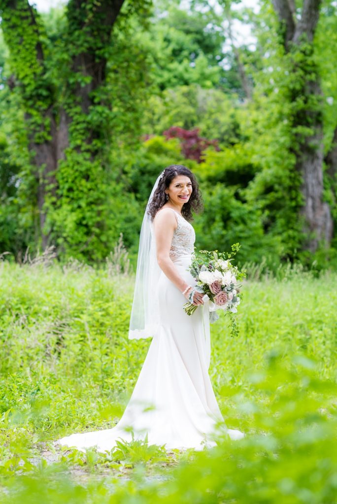 Westchester wedding photography at a beautiful outdoor and indoor venue called Crabtree's Kittle House. Photos by Mikkel Paige Photography. The bride's style was classic, wearing a deep v-neck lace gown by Paloma Blanca from Kleinfeld Bridal and white veil with lace edge. #mikkelpaige #westchestervenue #westchesterphotography #crabtreeskittlehouse #laceweddingdress #summerwedding #bridestyle