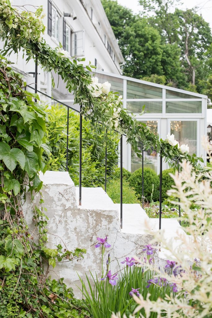 Pictures by Mikkel Paige Photography at the Westchester wedding venue, Crabtree's Kittle House. The ceremony was tented, photos outdoors and reception inside. White roses and Dogwood flowers with greenery decorated the grand staircase outside. #mikkelpaige #westchestervenue #westchesterphotography #crabtreeskittlehouse #summerwedding #ceremonyideas #receptionspace #eventreception #staircaseflowers