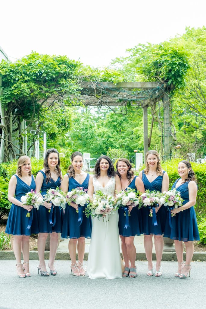 Westchester wedding photography at a beautiful outdoor and indoor venue called Crabtree's Kittle House. Photos by Mikkel Paige Photography. The bridesmaids wore midnight blue short chiffon dresses for the May Memorial Day Weekend wedding and carried purple and green bouquets by Denise Fasanello. #mikkelpaige #westchestervenue #westchesterphotography #crabtreeskittlehouse #bluebridesmaids #summerwedding