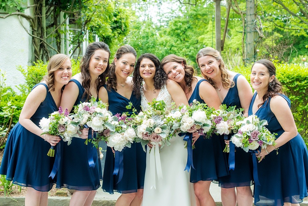 Westchester wedding photography at a beautiful outdoor and indoor venue called Crabtree's Kittle House. Photos by Mikkel Paige Photography. The bridesmaids wore midnight blue short chiffon dresses for the May Memorial Day Weekend wedding and carried purple and green bouquets by Denise Fasanello. #mikkelpaige #westchestervenue #westchesterphotography #crabtreeskittlehouse #bluebridesmaids #summerwedding