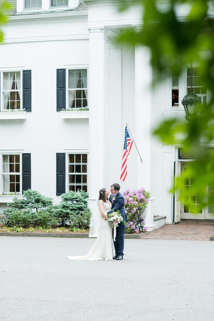 Westchester wedding photography at a beautiful outdoor and indoor venue called Crabtree's Kittle House. Photos by Mikkel Paige Photography. The bride and groom looked classic in a blue suit and v-neck summer lace gown with a deep back. They had a bouquet and boutonniere with poppy pods, scabiosas and roses in a purple + green palette. #mikkelpaige #westchestervenue #westchesterphotography #crabtreeskittlehouse #bridestyle #Maywedding #brideandgroom