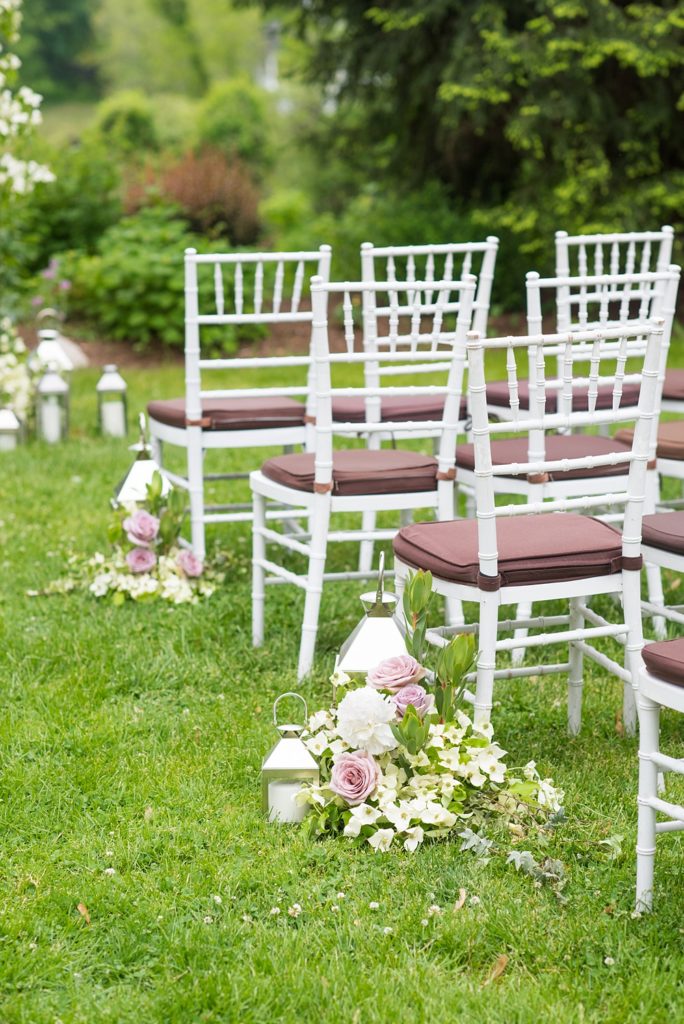 Westchester wedding photography by Mikkel Paige Photography at a beautiful venue called Crabtree's Kittle House. Their outdoor ceremony had Jewish traditions like breaking of a glass and their friend officiated. Purple and white flowers, including roses and dogwoods, lined the aisle with lanterns and greenery. #mikkelpaige #westchestervenue #westchesterphotography #crabtreeskittlehouse #summerwedding #weddingceremony #weddingtent