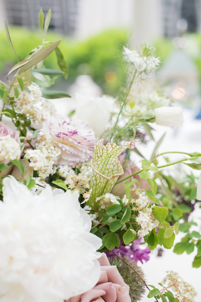 Pictures by Mikkel Paige Photography at the Westchester wedding venue, Crabtree's Kittle House. The ceremony was tented, photos outdoor and reception inside. Purple and white flowers with greenery were centerpieces in the intimate space including Pitcher Plants, ranunculus and roses. #mikkelpaige #westchestervenue #westchesterphotography #crabtreeskittlehouse #summerwedding #receptionspace #eventreception #purplewedding #purplepalette