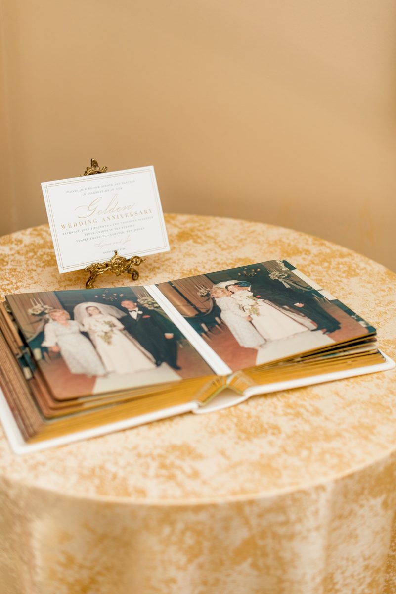 Photographs at New Jersey wedding venue, Temple Emanu-el, by Mikkel Paige Photography, with kosher catering for a golden 50th anniversary celebration. Decor with metallic and white flowers for the romantic space. Fun-loving couple providing beautiful inspiration with cute signs, table numbers and giveaways. All paper and signs by @suitepaperie. The couple displayed their original album. #mikkelpaige #newjerseyweddingphotographer #newjerseyweddingvenue #njweddingphotographers #50thanniversary