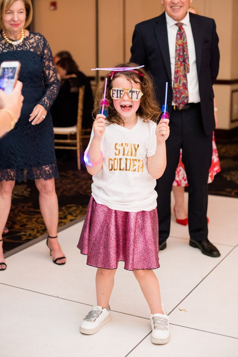 Photographs at New Jersey wedding venue, Temple Emanu-el, by Mikkel Paige Photography, with kosher catering for a golden 50th anniversary celebration. Decor with metallic and white flowers for the romantic space. Fun-loving couple providing beautiful inspiration with cute signs, table numbers and giveaways. All paper and signs by @suitepaperie. #mikkelpaige #newjerseyweddingphotographer #newjerseyweddingvenue #njweddings #njweddingphotographers