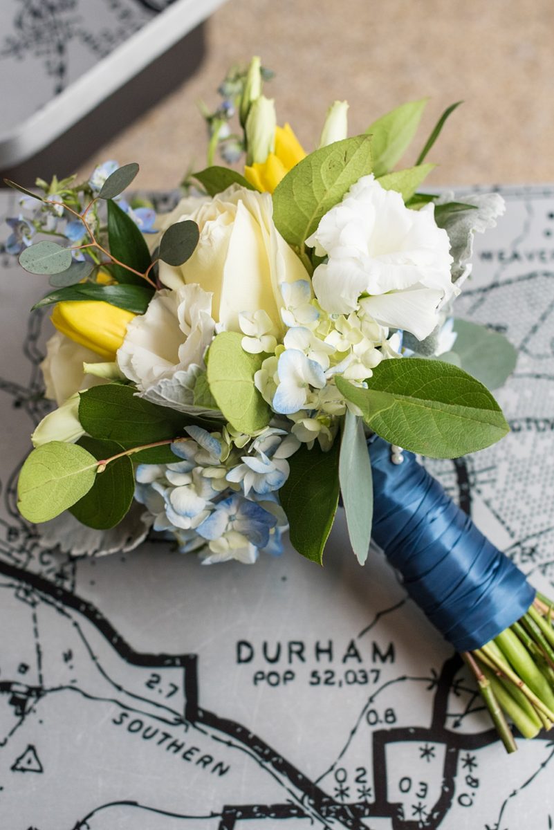 Pictures at a Durham, North Carolina wedding venue by Mikkel Paige Photography. The Rickhouse was the perfect indoor space for the bride and groom's ceremony + reception. They got ready at 21c Museum hotel and took beautiful outdoor photos in the summer sun. The bride chose yellow and blue for the decor including bridesmaids bouquets. #mikkelpaige #therickhouse #durhamweddingphotos #durhamwedding #northcarolinaweddingphotographer #durhamweddingphotographer #summerwedding #yellowbouquets
