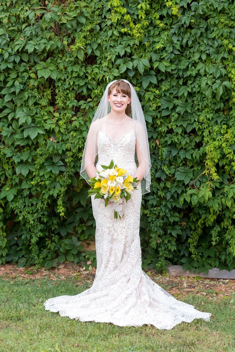 Pictures at a Durham, North Carolina wedding venue by Mikkel Paige Photography. The Rickhouse was the perfect indoor space for the bride and groom's ceremony + reception. They got ready at 21c Museum hotel and took beautiful outdoor photos in the summer sun. The bride chose yellow for her bouquet and a lace v-neck gown for her style. #mikkelpaige #therickhouse #durhamweddingphotos #durhamwedding #northcarolinaweddingphotographer #durhamweddingphotographer #blueandyellow #summerwedding #lacegown