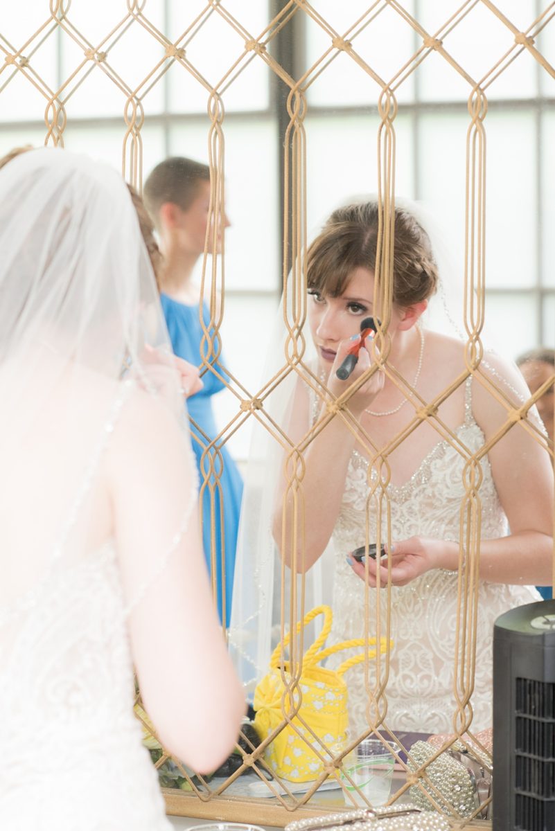 Pictures at a Durham, North Carolina wedding venue by Mikkel Paige Photography. The Rickhouse was the perfect indoor space for the bride and groom's ceremony + reception. They got ready at 21c Museum hotel and took beautiful outdoor photos in the summer sun. The bride chose yellow for her bouquet and a lace v-neck gown for her style. #mikkelpaige #therickhouse #durhamweddingphotos #durhamwedding #northcarolinaweddingphotographer #durhamweddingphotographer #blueandyellow #summerwedding #lacegown