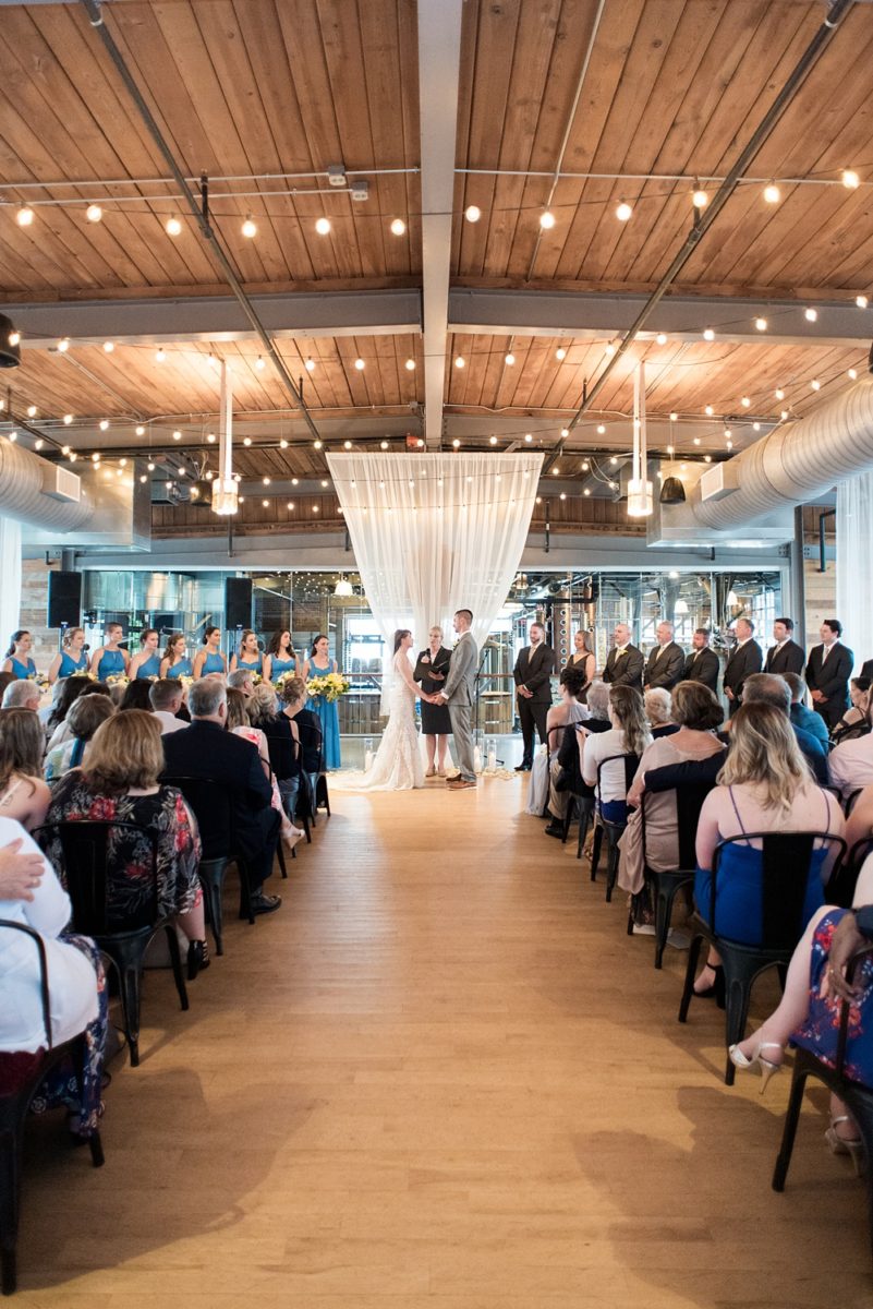 Pictures at a Durham, North Carolina wedding venue by Mikkel Paige Photography. The Rickhouse was the perfect outdoor/indoor space for the bride and groom's reception and ceremony. The couple chose fun yellow and blue colors for their summer decor. #mikkelpaige #therickhouse #durhamweddingphotos #durhamwedding #northcarolinaweddingphotographer #durhamweddingphotographer