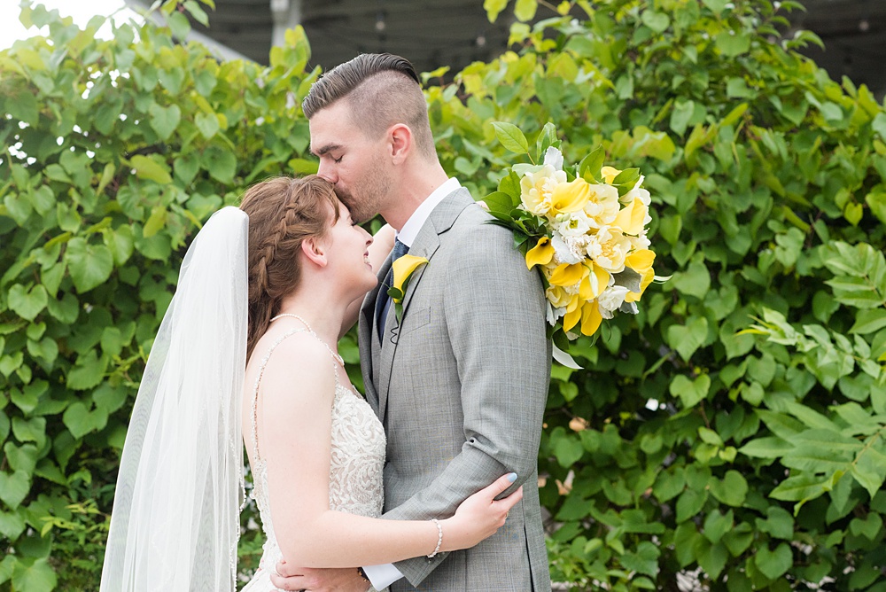 Pictures at a Durham, North Carolina wedding venue by Mikkel Paige Photography. The Rickhouse was the perfect indoor space for the bride and groom's ceremony and reception. They got ready at 21c Museum hotel and took beautiful outdoor photos in the summer sun. The couple chose fun yellow and blue colors for beautiful reception decor. #mikkelpaige #therickhouse #durhamweddingphotos #durhamwedding #northcarolinaweddingphotographer #durhamweddingphotographer #blueandyellow #summerwedding