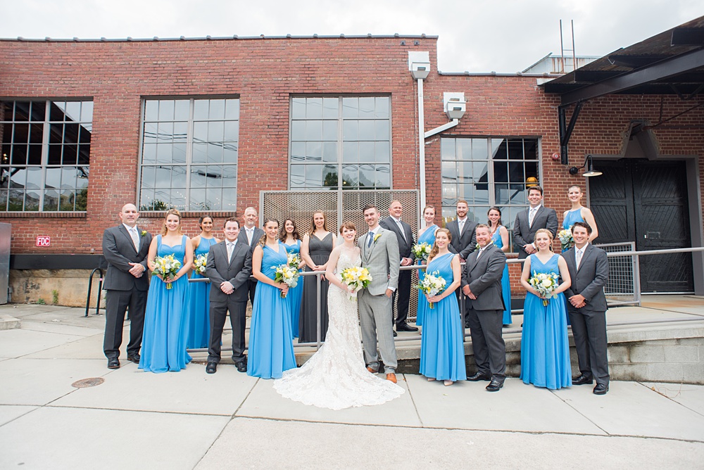 Pictures at a Durham, North Carolina wedding venue by Mikkel Paige Photography. The Rickhouse was a perfect indoor space for the bride and groom's ceremony + reception. They got ready at 21c Museum hotel and took beautiful outdoor photos in the summer sun. The couple chose fun yellow hues for the bouquets and a Carolina blue for beautiful bridesmaids gowns. #mikkelpaige #therickhouse #durhamweddingphotos #durhamwedding #northcarolinaweddingphotographer #durhamweddingphotographer #bluebridesmaids