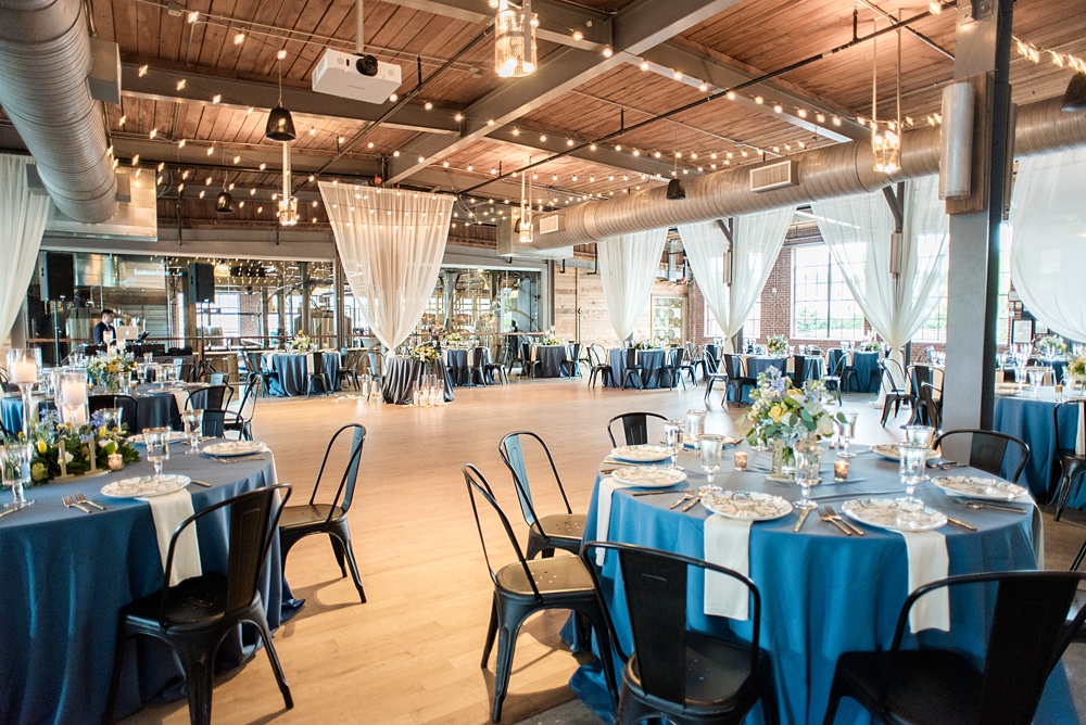 Pictures at a Durham, North Carolina wedding venue by Mikkel Paige Photography. The Rickhouse was the perfect outdoor/indoor space for the bride and groom's celebration. The couple chose fun yellow and blue colors for their summer reception and simple yet beautiful reception decor. #mikkelpaige #therickhouse #durhamweddingphotos #durhamwedding #northcarolinaweddingphotographer #durhamweddingphotographer #blueandyellow #summerwedding