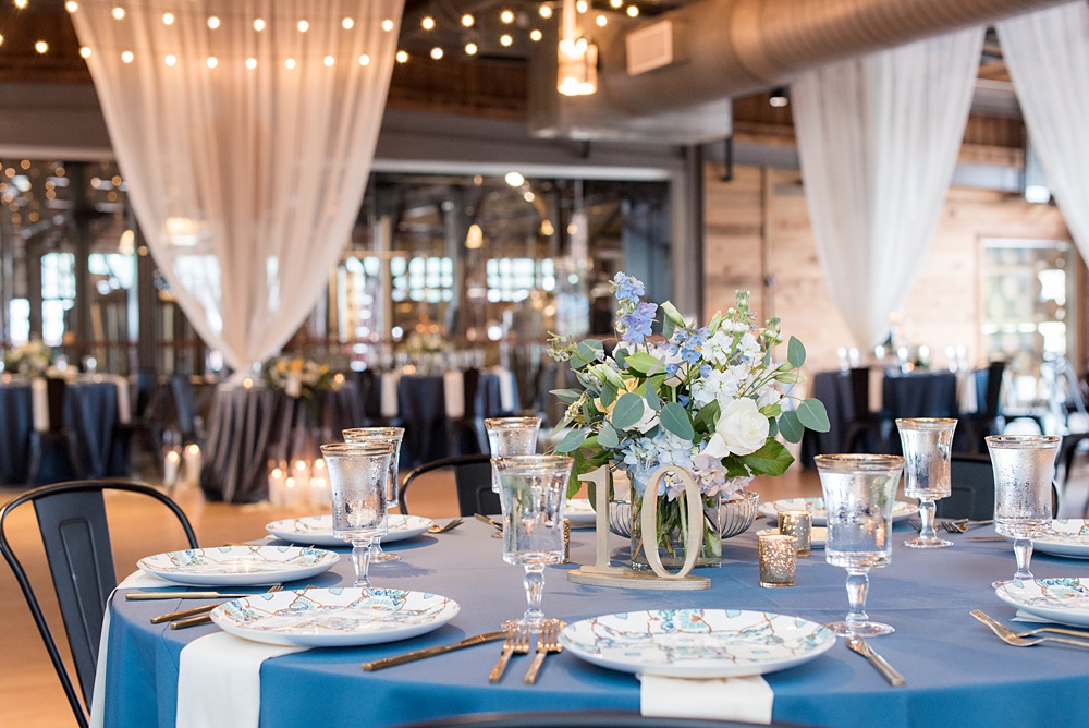 Pictures at a Durham, North Carolina wedding venue by Mikkel Paige Photography. The Rickhouse was the perfect outdoor/indoor space for the bride and groom's celebration. The couple chose fun yellow and blue colors for their summer reception and simple yet beautiful reception decor. #mikkelpaige #therickhouse #durhamweddingphotos #durhamwedding #northcarolinaweddingphotographer #durhamweddingphotographer #blueandyellow #summerwedding