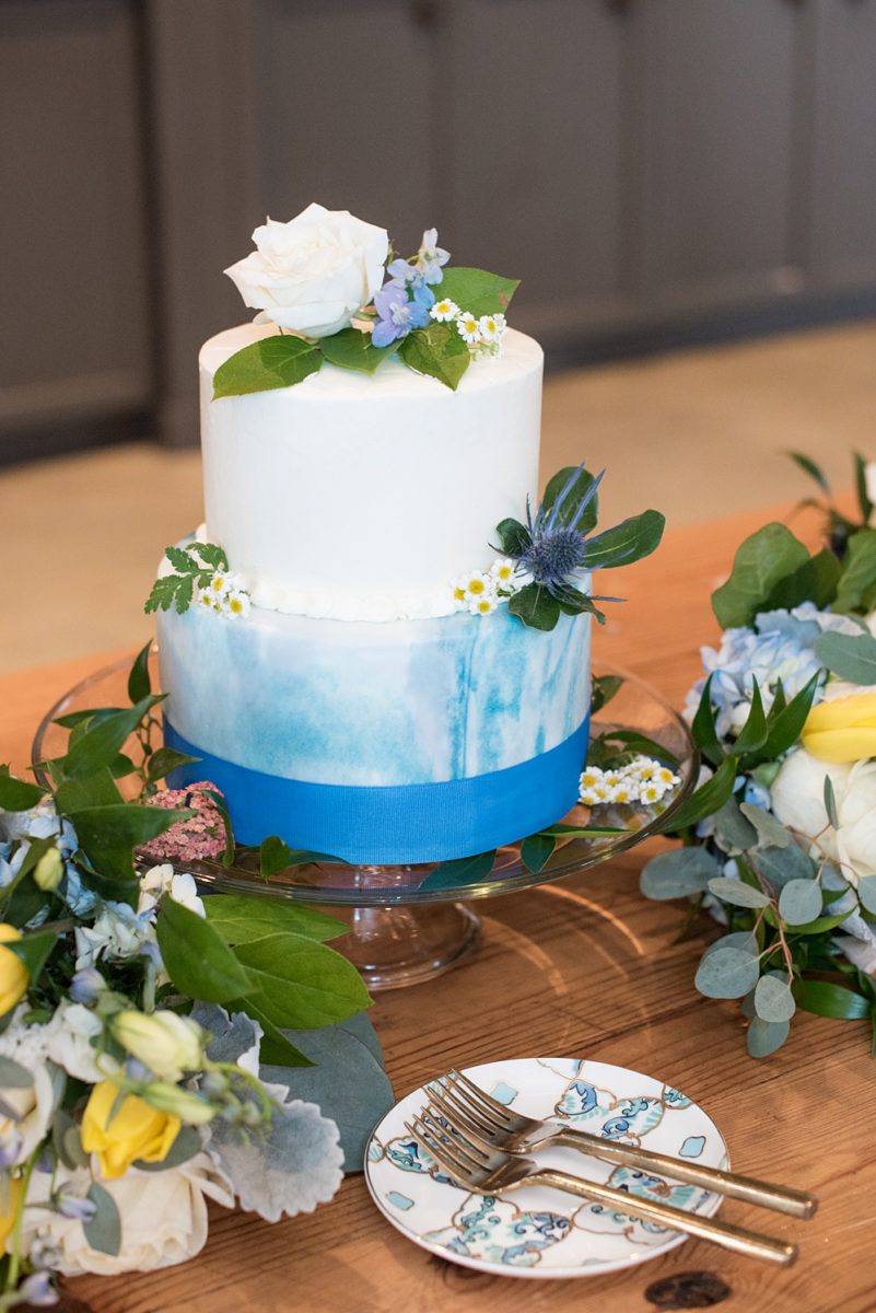 Pictures at a Durham, North Carolina wedding venue by Mikkel Paige Photography. The Rickhouse was the perfect outdoor/indoor space for the bride and groom's reception and ceremony. The couple chose fun yellow and blue colors for their summer decor and their small buttercream cake matched with ombre marble designs and floral decorations. #mikkelpaige #therickhouse #durhamweddingphotos #durhamwedding #northcarolinaweddingphotographer #durhamweddingphotographer