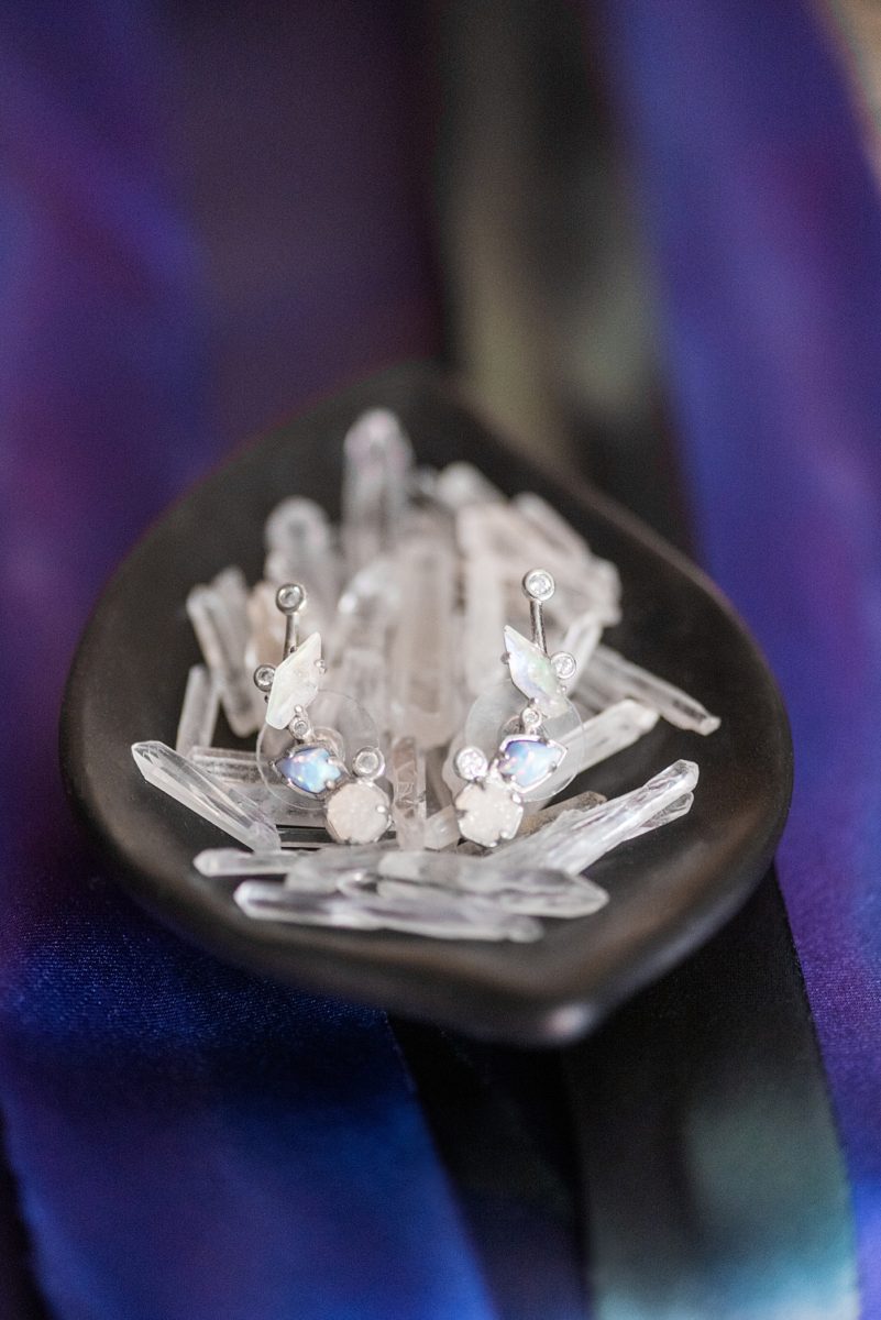 Detail photos of wedding earrings by Mikkel Paige Photography, of Kendra Scott climbers with opal details on a bed of crystal quartz points. #MikkelPaige #Crystals #Quartz #WeddingEarrings #Climbers #KendraScott
