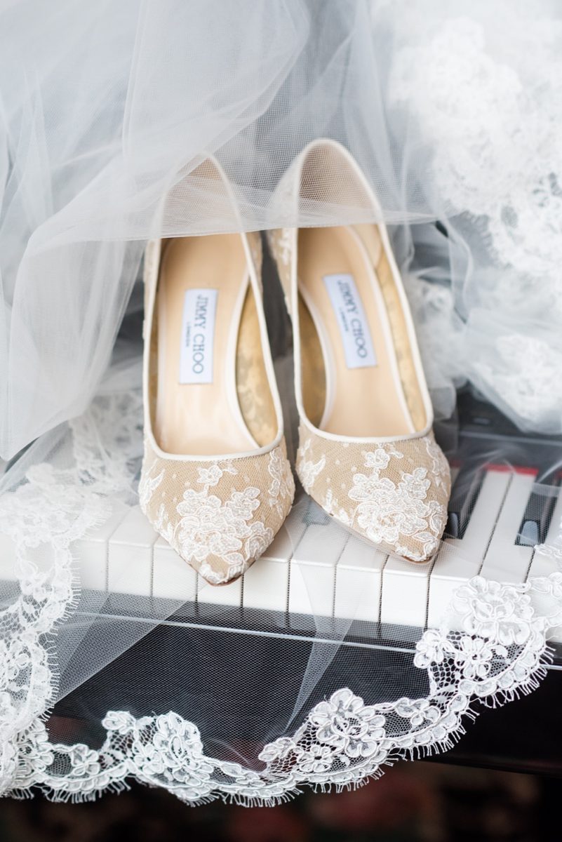 Picture of the bride's lace Jimmy Choo shoes on Long Island by Mikkel Paige Photography for her East Wind wedding in Wading River, NY. The wedding venue has a beautiful outdoor ceremony area and pretty indoor reception space. #mikkelpaige #newyorkweddingphotographer #longislandweddingvenue #summerbride #laceweddinggown #bridestyle #weddingdetails #JimmyChoo #weddingshoes #laceshoes