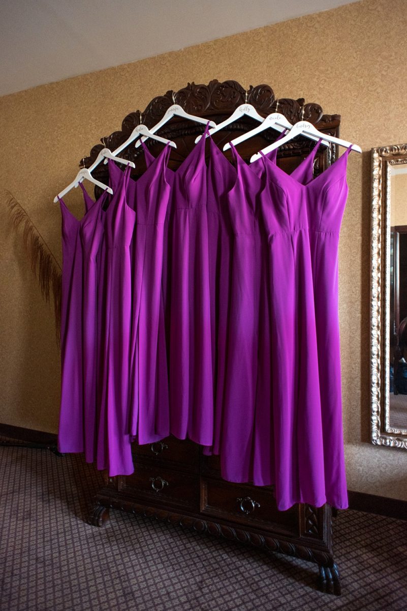 Picture of the bridesmaids dresses during getting ready time on Long Island by Mikkel Paige Photography for her East Wind wedding in Wading River, NY. The wedding venue has a beautiful outdoor ceremony area and pretty indoor reception space. #mikkelpaige #newyorkweddingphotographer #longislandweddingvenue #summerwedding #weddingdetails #purplebridesmaids #bridesmaidsgowns