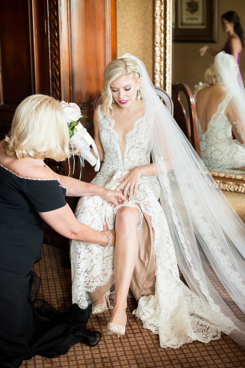 Photos of the bride and her mother getting ready on Long Island by Mikkel Paige Photography for her East Wind wedding in Wading River, NY. The wedding venue has a beautiful outdoor ceremony area and pretty indoor reception space. #mikkelpaige #newyorkweddingphotographer #longislandweddingvenue #summerbride #laceweddinggown #bridestyle #weddingdetails #gettingready #garterbelt