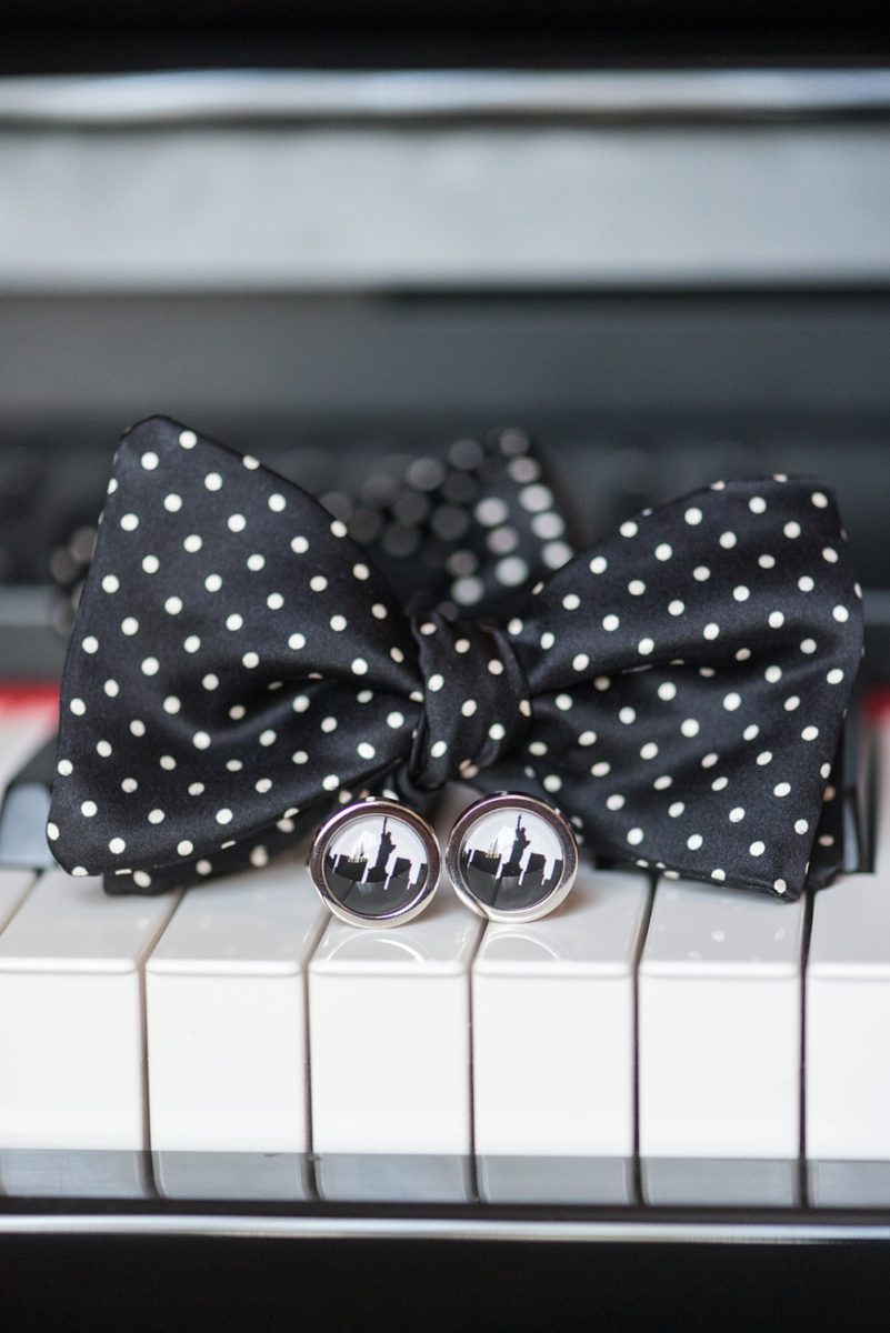 Detail pictures of the groom's black and white polka dot bow tie and NYC skyline cufflinks by Mikkel Paige Photography at an East Wind wedding in Wading River, NY on Long Island. The wedding venue has a beautiful outdoor ceremony area and pretty indoor reception space. #mikkelpaige #newyorkweddingphotographer #longislandweddingvenue #groomstyle #NYCskyline #cufflinks
