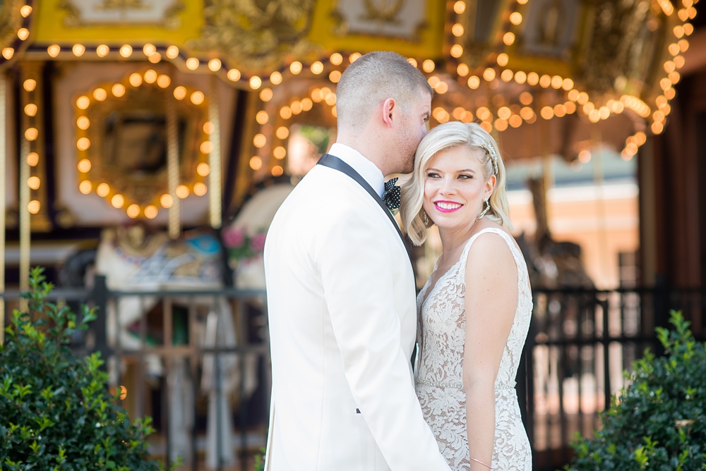 Photos of the bride and groom by a carousel by Mikkel Paige Photography at an East Wind wedding in Wading River, NY on Long Island. The wedding venue has a beautiful outdoor ceremony area and pretty indoor reception space. #mikkelpaige #newyorkweddingphotographer #longislandweddingvenue #summerbride #laceweddinggown #bridestyle #BrideandGroom