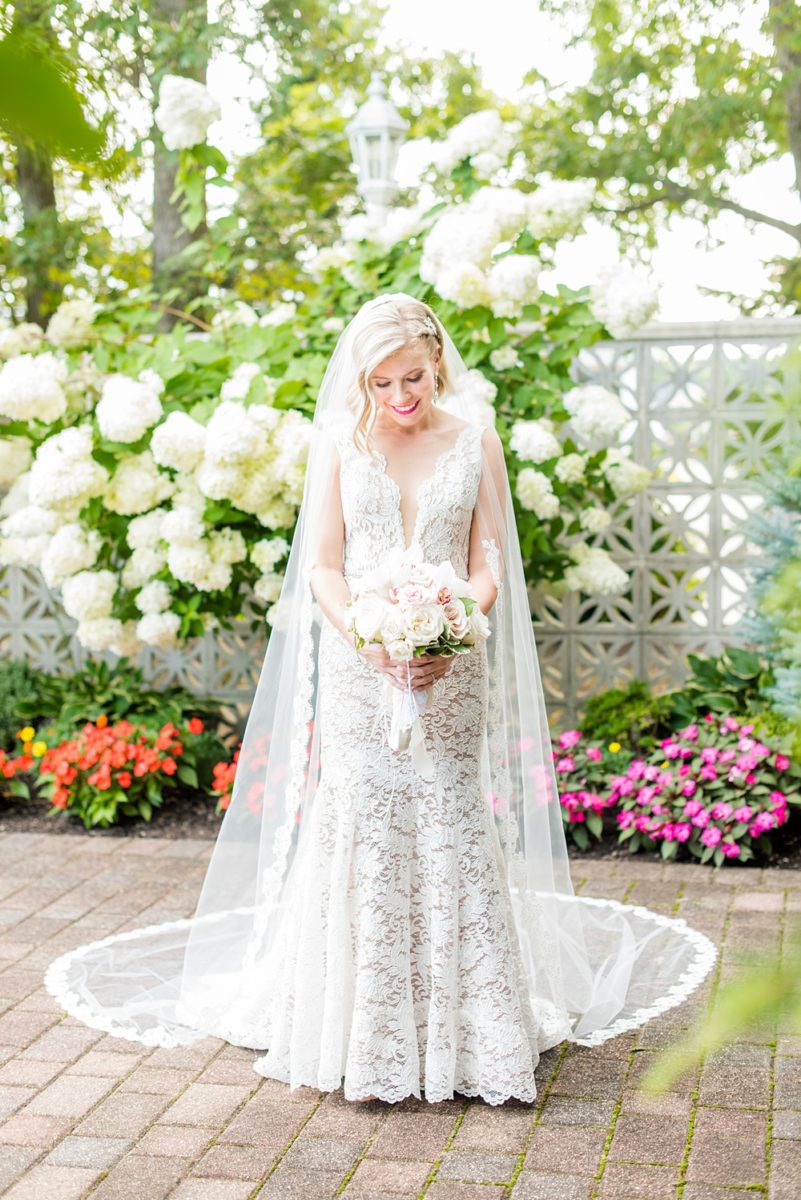 Photos of the bride by Mikkel Paige Photography at an East Wind wedding in Wading River, NY on Long Island. The wedding venue has a beautiful outdoor ceremony area and pretty indoor reception space. #mikkelpaige #newyorkweddingphotographer #longislandweddingvenue #summerbride #laceweddinggown #bridestyle