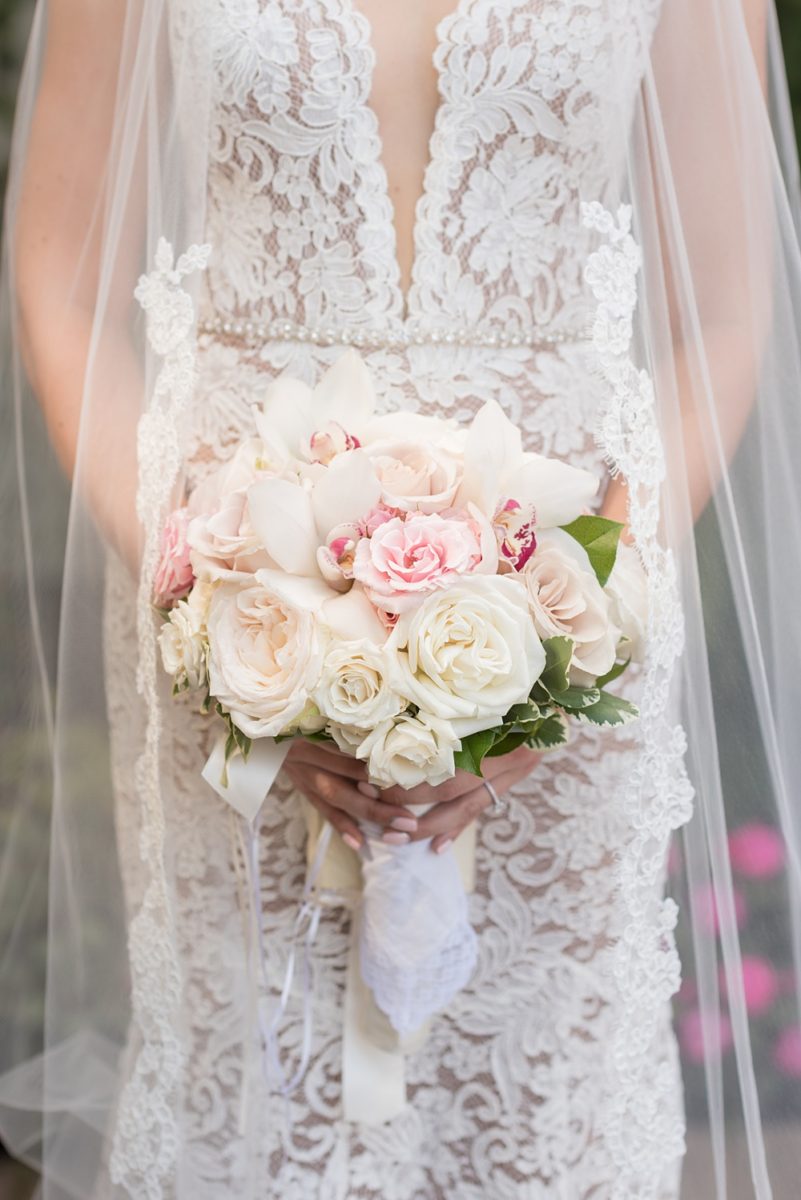 Photos of the bride's orchid and rose bouquet by Mikkel Paige Photography at an East Wind wedding in Wading River, NY on Long Island. The wedding venue has a beautiful outdoor ceremony area and pretty indoor reception space. #mikkelpaige #newyorkweddingphotographer #longislandweddingvenue #summerbride #roseandorchidbouquet #bridestyle