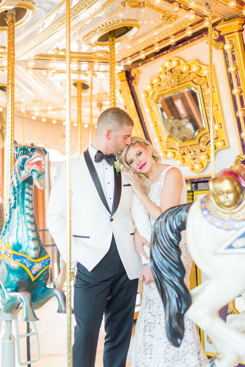 Photos of the bride and groom on a carousel by Mikkel Paige Photography at an East Wind wedding in Wading River, NY on Long Island. The wedding venue has a beautiful outdoor ceremony area and pretty indoor reception space. #mikkelpaige #newyorkweddingphotographer #longislandweddingvenue #summerbride #laceweddinggown #bridestyle #BrideandGroom