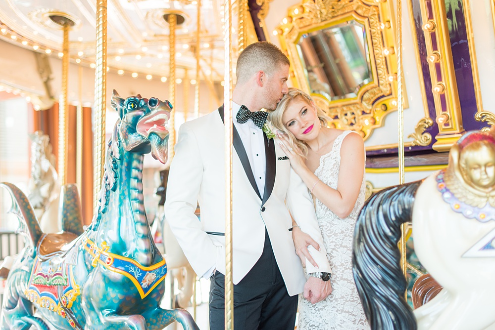 Photos of the bride and groom on a carousel by Mikkel Paige Photography at an East Wind wedding in Wading River, NY on Long Island. The wedding venue has a beautiful outdoor ceremony area and pretty indoor reception space. #mikkelpaige #newyorkweddingphotographer #longislandweddingvenue #summerbride #laceweddinggown #bridestyle #BrideandGroom