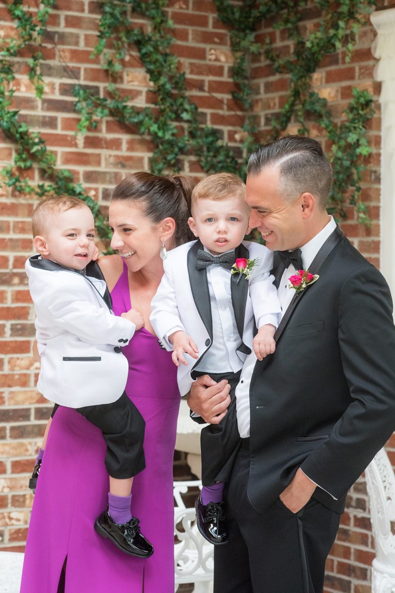 Photos of the ring bearers in white tuxedos during a summer event by Mikkel Paige Photography at an East Wind wedding in Wading River, NY on Long Island. The venue has a beautiful outdoor ceremony area and pretty indoor reception space. #mikkelpaige #newyorkweddingphotographer #longislandweddingvenue #ringbearers
