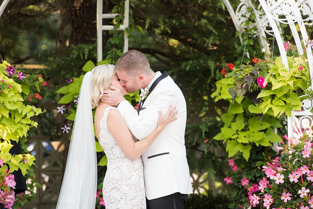 An outdoor ceremony during a summer event, photographed by Mikkel Paige Photography at an East Wind wedding in Wading River, NY on Long Island. The venue has a beautiful indoor reception space as well. #mikkelpaige #newyorkweddingphotographer #longislandweddingvenue #outdoorceremony #ceremony #firstkiss