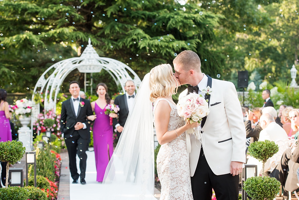 An outdoor ceremony and bubble exit during a summer event, photographed by Mikkel Paige Photography at an East Wind wedding in Wading River, NY on Long Island. The venue has a beautiful indoor reception space as well. #mikkelpaige #newyorkweddingphotographer #longislandweddingvenue #outdoorceremony #ceremony #bubbleexit