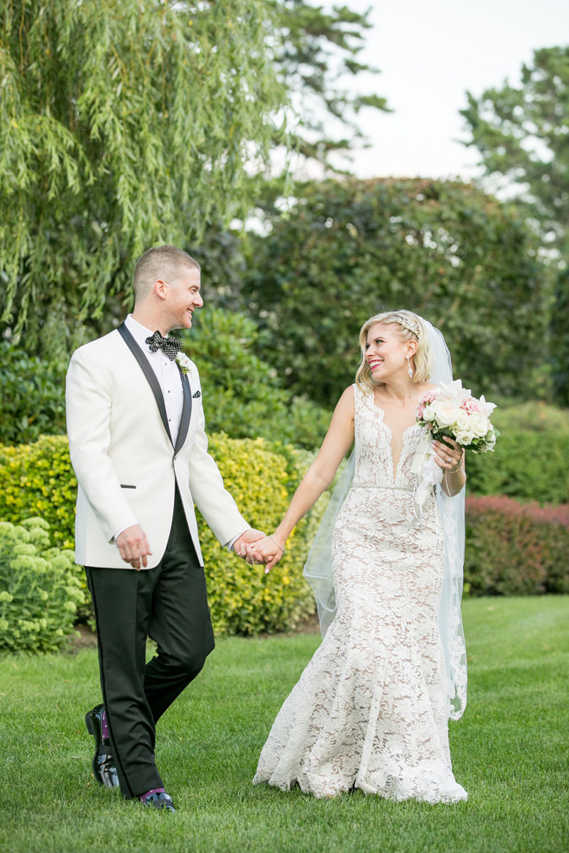 Sunset photos of the bride and groom during a summer event by Mikkel Paige Photography at an East Wind wedding in Wading River, NY on Long Island. The wedding venue has a beautiful outdoor ceremony area and pretty indoor reception space. #mikkelpaige #newyorkweddingphotographer #longislandweddingvenue #brideandgroom #goldenhour