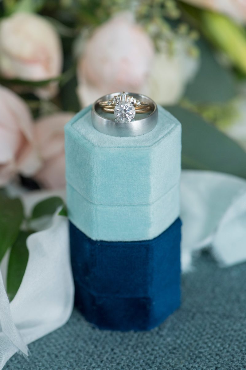 Wedding rings detail picture with blue velvet ring boxes for a Saratoga Springs waterfront wedding. Photos by Mikkel Paige Photography. The bride and groom created a venue from a rental property and had an "at home" style celebration at a lakehouse. #SaratogaSprings #weddingrings #velvetringboxes #mikkelpaige 