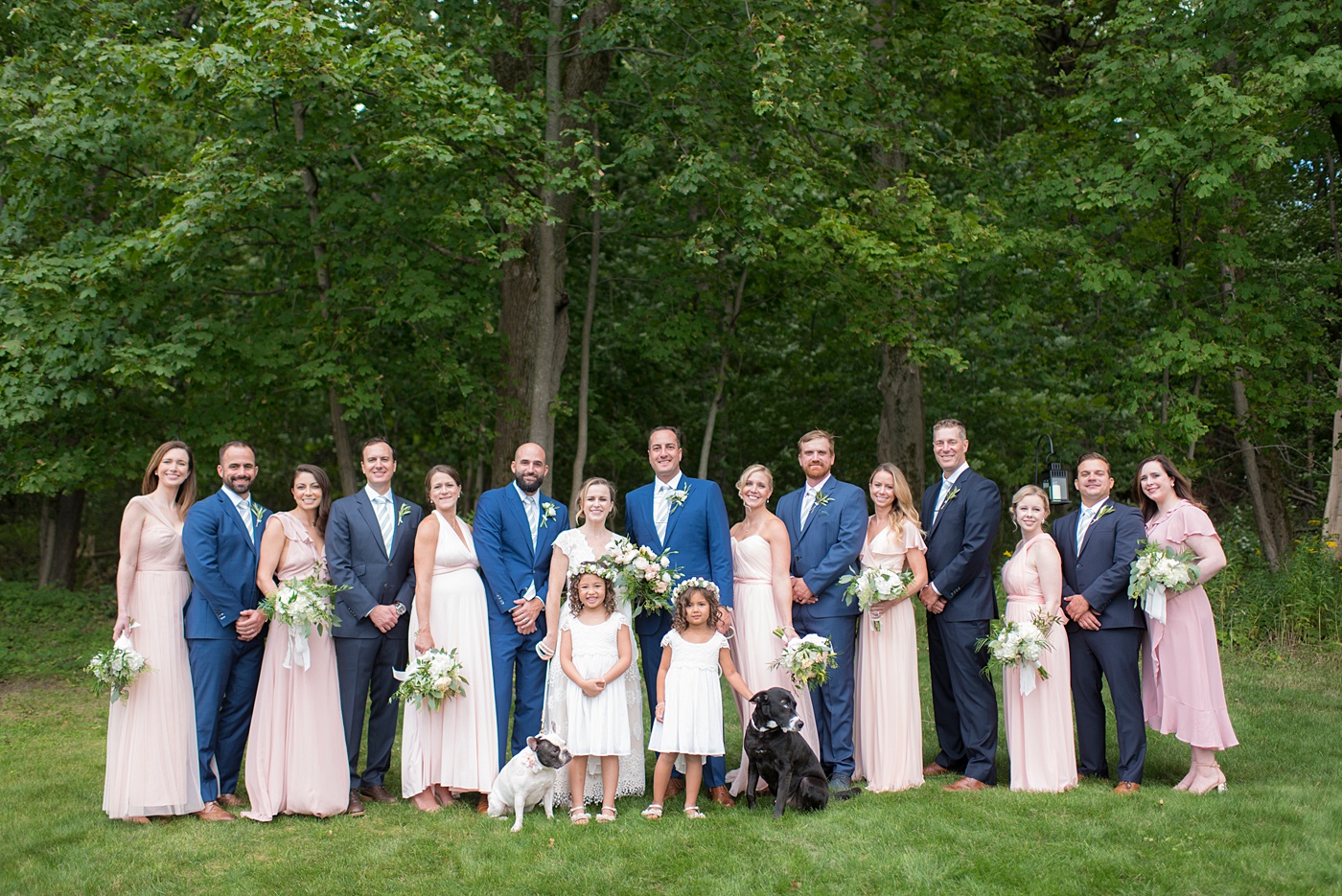 Saratoga Springs waterfront wedding photos of the bridal party in pink bridesmaids dresses and blue suits, by Mikkel Paige Photography. The bride and groom created a venue from a rental property and had an "at home" style celebration at a lakehouse. #SaratogaSprings #lakefrontwedding #lakewedding #mikkelpaige #pinkbridesmaids #bluesuits