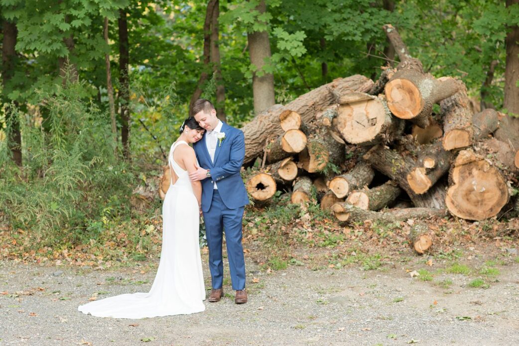 The bride and groom at their Crabtree's Kittle House wedding with an outdoor ceremony and indoor reception in Chappaqua, New York. Photos by Mikkel Paige Photography. This venue in Westchester County is near the Hudson Valley and NYC. She wore an elegant, form-fitting white gown with open back. He wore a blue suit, gray tie and rose boutonniere. #mikkelpaige #hudsonvalleyweddings #crabtreeskittlehouse #fallwedding #westchestervenues #bridestyle #elegantbride #groomstyle #filipinobride