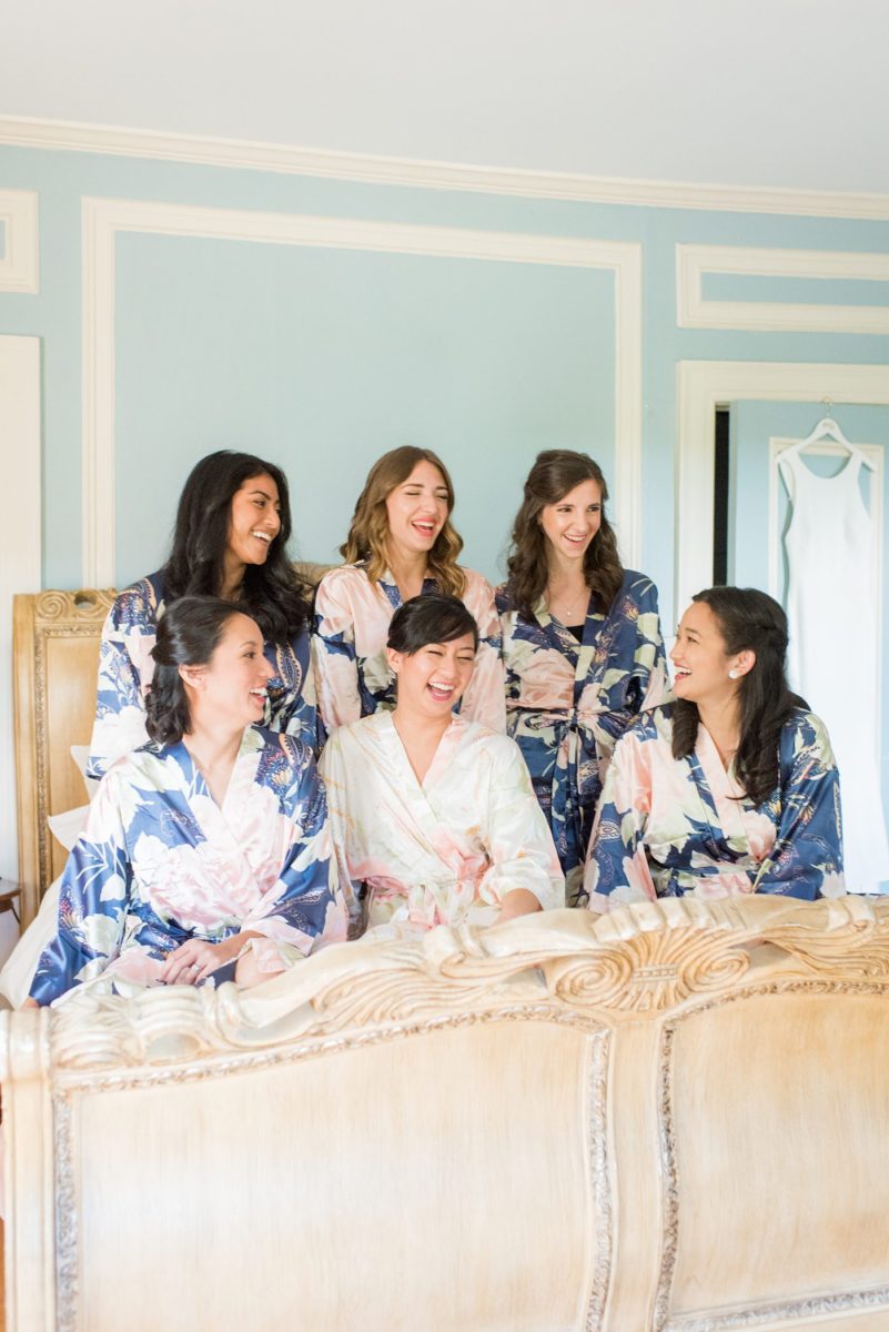 The bride and her bridesmaids got ready for her wedding at Crabtree's Kittle House in Chappaqua, New York at the boutique hotel in floral robes. Photos by Mikkel Paige Photography. This venue in Westchester County is near the Hudson Valley and NYC. She wore an elegant, form-fitting white gown with open back with her hair braided and in a low bun. #mikkelpaige #hudsonvalleyweddings #crabtreeskittlehouse #fallwedding #westchestervenues #bridestyle #filipinobride #weddingday #floralrobes