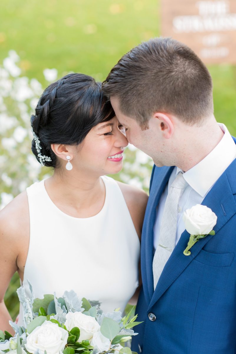 The bride and groom at their Crabtree's Kittle House wedding with an outdoor ceremony and indoor reception in Chappaqua, New York. Photos by Mikkel Paige Photography. This venue in Westchester County is near the Hudson Valley and NYC. She wore an elegant, form-fitting white gown with open back. He wore a blue suit, gray tie and rose boutonniere. #mikkelpaige #hudsonvalleyweddings #crabtreeskittlehouse #fallwedding #westchestervenues #bridestyle #elegantbride #groomstyle #filipinobride