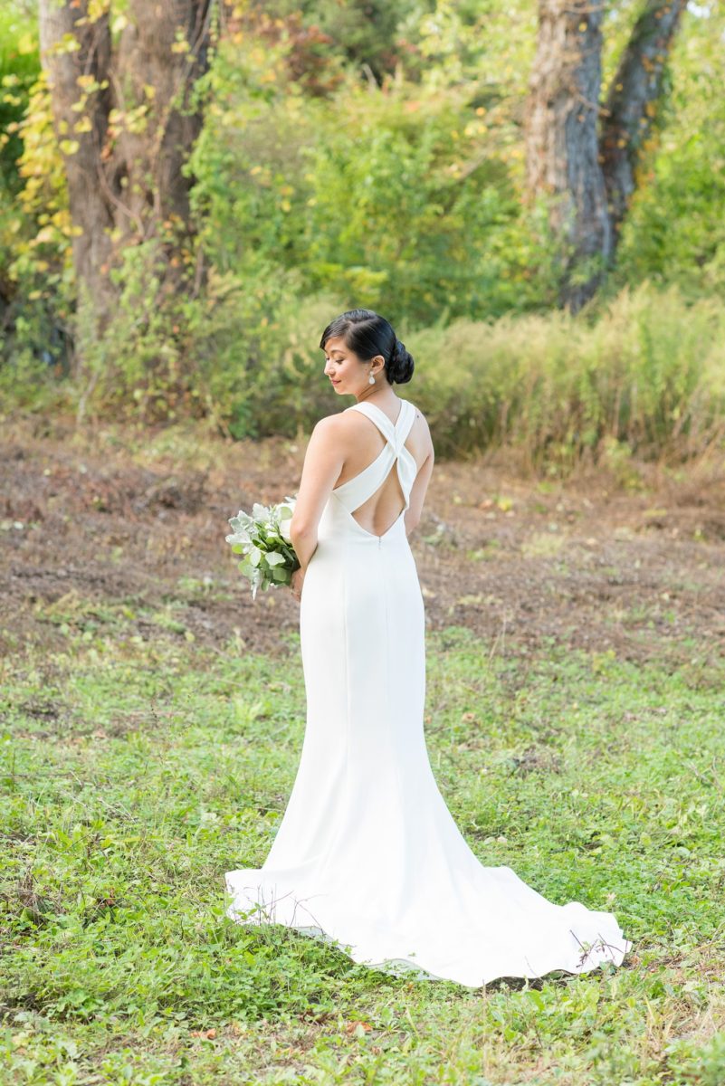 The bride and groom at their Crabtree's Kittle House wedding with an outdoor ceremony and indoor reception in Chappaqua, New York. Photos by Mikkel Paige Photography. This venue in Westchester County is near the Hudson Valley and NYC. She wore an elegant, form-fitting white gown with open back with her hair braided and in a low bun. #mikkelpaige #hudsonvalleyweddings #crabtreeskittlehouse #fallwedding #westchestervenues #bridestyle #elegantbride #filipinobride
