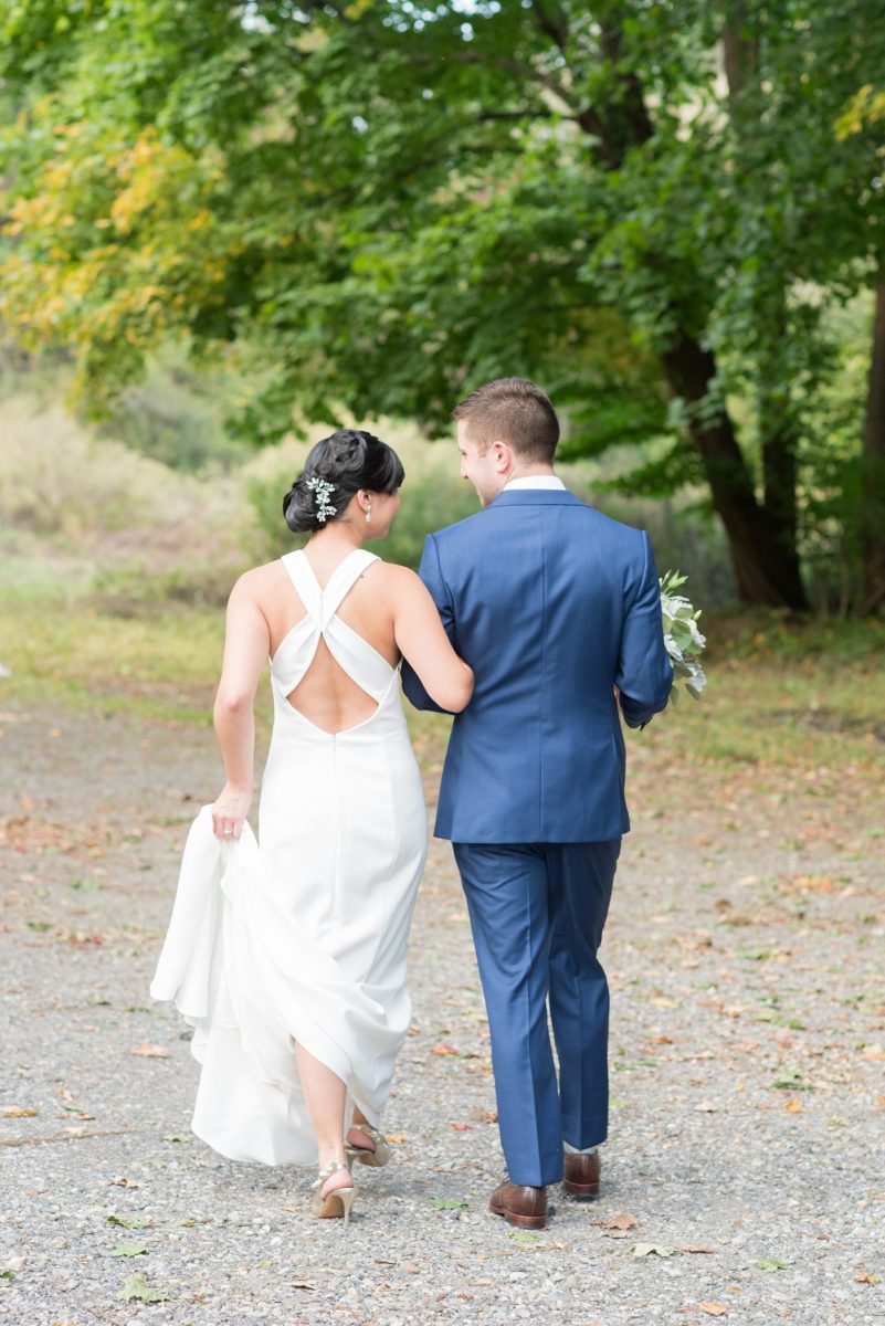 The bride and groom at their Crabtree's Kittle House wedding with an outdoor ceremony and indoor reception in Chappaqua, New York. Photos by Mikkel Paige Photography. This venue in Westchester County is near the Hudson Valley and NYC. She wore an elegant, form-fitting white gown with open back. He wore a blue suit, gray tie and rose boutonniere. #mikkelpaige #hudsonvalleyweddings #crabtreeskittlehouse #fallwedding #westchestervenues #bridestyle #elegantbride #groomstyle #filipinobride