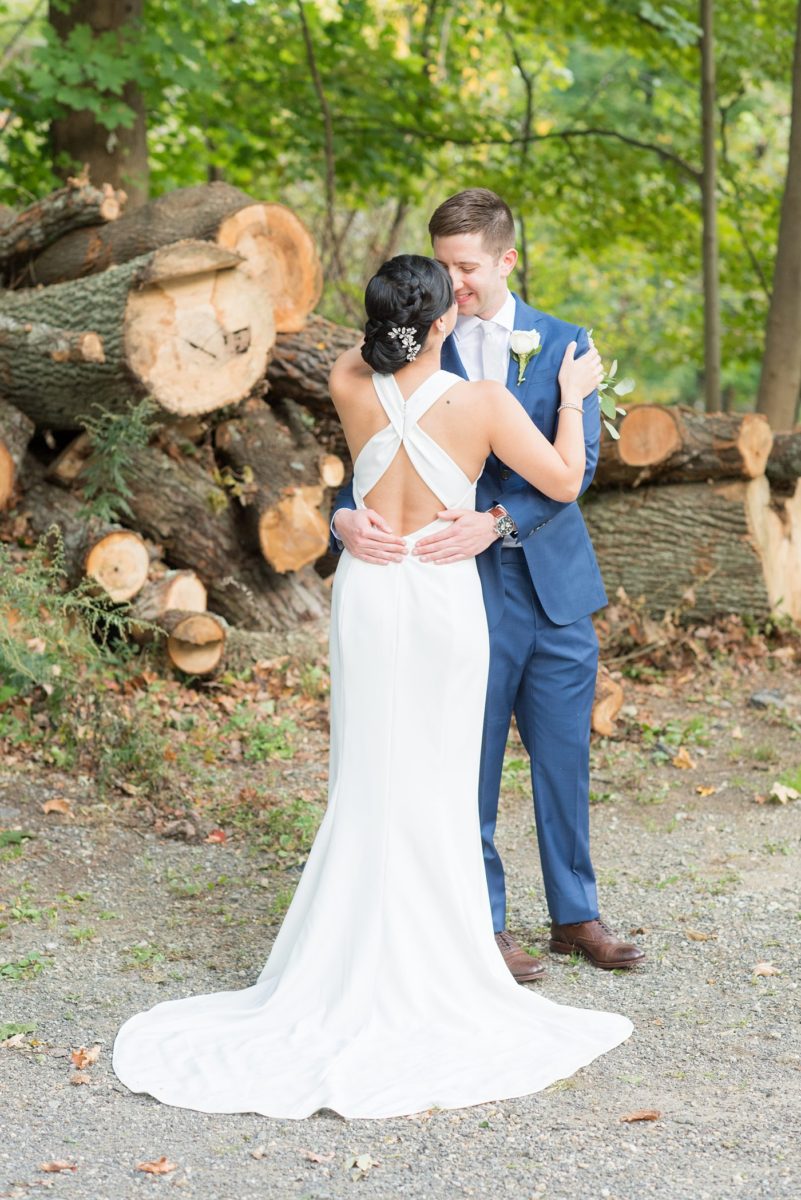 The bride and groom at their Crabtree's Kittle House wedding with an outdoor ceremony and indoor reception in Chappaqua, New York. Photos by Mikkel Paige Photography. This venue in Westchester County is near the Hudson Valley and NYC. She wore an elegant, form-fitting white gown with open back. He wore a gray suit, blue tie and rose boutonniere. #mikkelpaige #hudsonvalleyweddings #crabtreeskittlehouse #fallwedding #westchestervenues #bridestyle #elegantbride #groomstyle #filipinobride