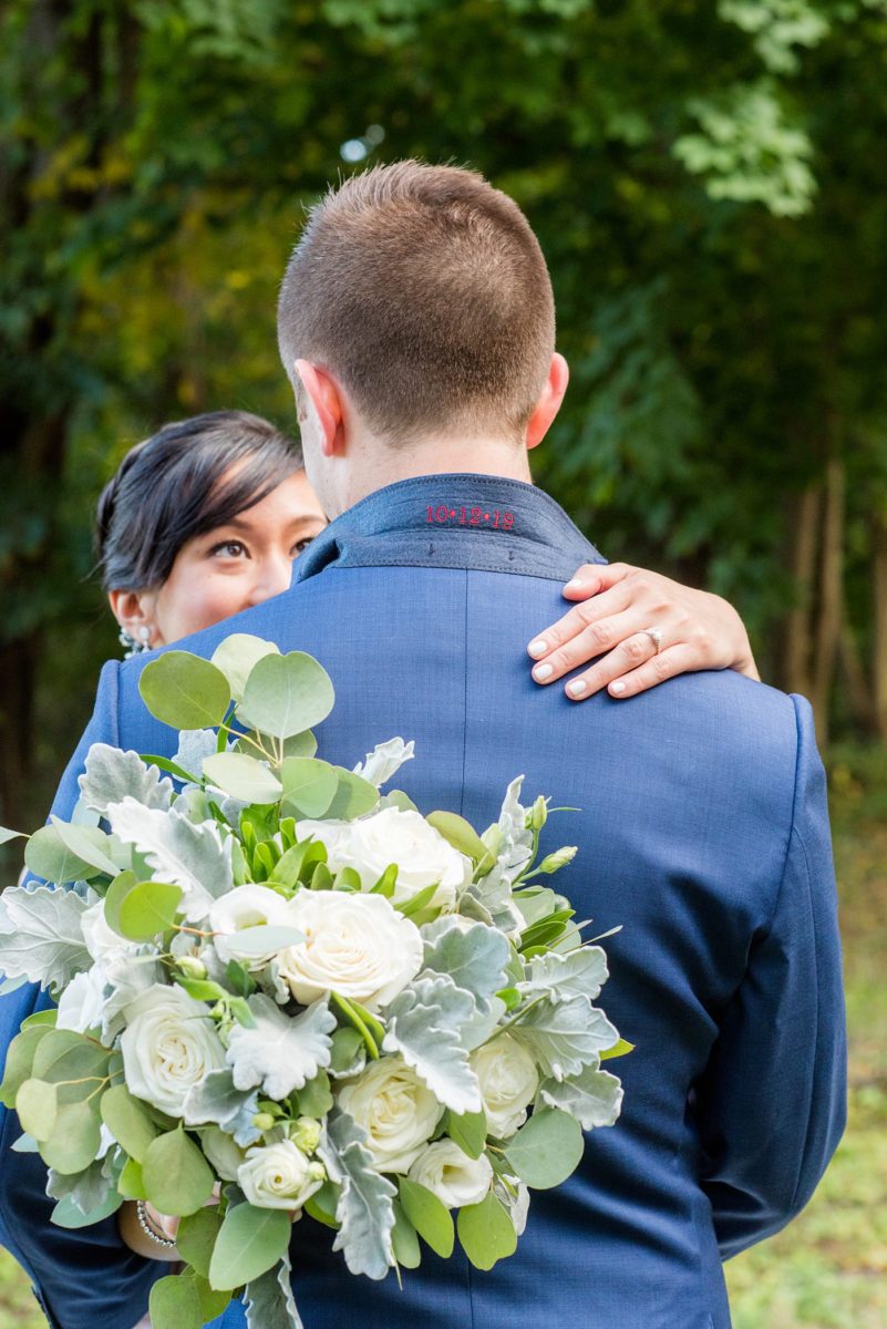 The bride and groom at their Crabtree's Kittle House wedding with an outdoor ceremony and indoor reception in Chappaqua, New York. Photos by Mikkel Paige Photography of the groom's collar on his custom suit with red embroidered wedding date. This venue in Westchester County is near the Hudson Valley and NYC. #mikkelpaige #hudsonvalleyweddings #crabtreeskittlehouse #fallwedding #westchestervenues #groom #elegantbride #groomstyle #filipinobride #customsuit