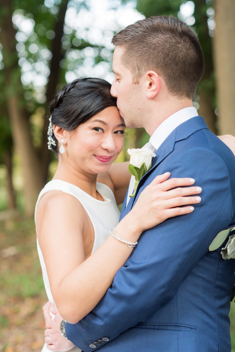 The bride and groom at their Crabtree's Kittle House wedding with an outdoor ceremony and indoor reception in Chappaqua, New York. Photos by Mikkel Paige Photography. This venue in Westchester County is near the Hudson Valley and NYC. She wore an elegant, form-fitting white gown with open back. He wore a blue suit, gray tie and rose boutonniere. #mikkelpaige #hudsonvalleyweddings #crabtreeskittlehouse #fallwedding #westchestervenues #bridestyle #elegantbride #groomstyle #filipinobride