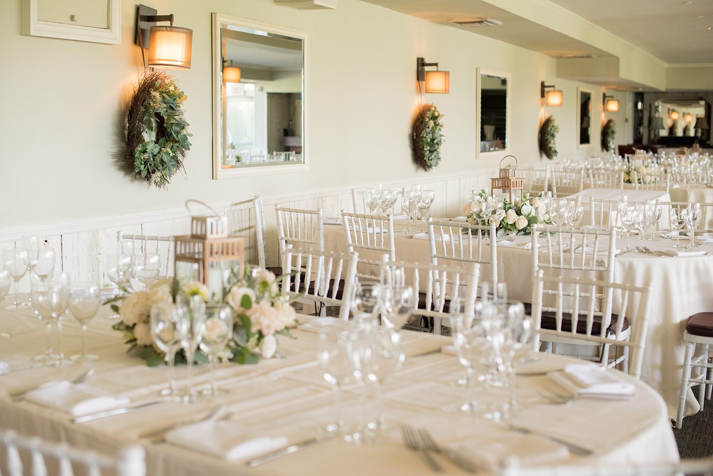 Indoor reception at Crabtree's Kittle House wedding after an outdoor ceremony in Chappaqua, New York. Table photos with lanterns and white dahlia and rose centerpieces by Mikkel Paige Photography. This venue in Westchester County is near the Hudson Valley and NYC. #mikkelpaige #hudsonvalleyweddings #crabtreeskittlehouse #fallwedding #westchestervenues #reception #dahlias #centerpieces