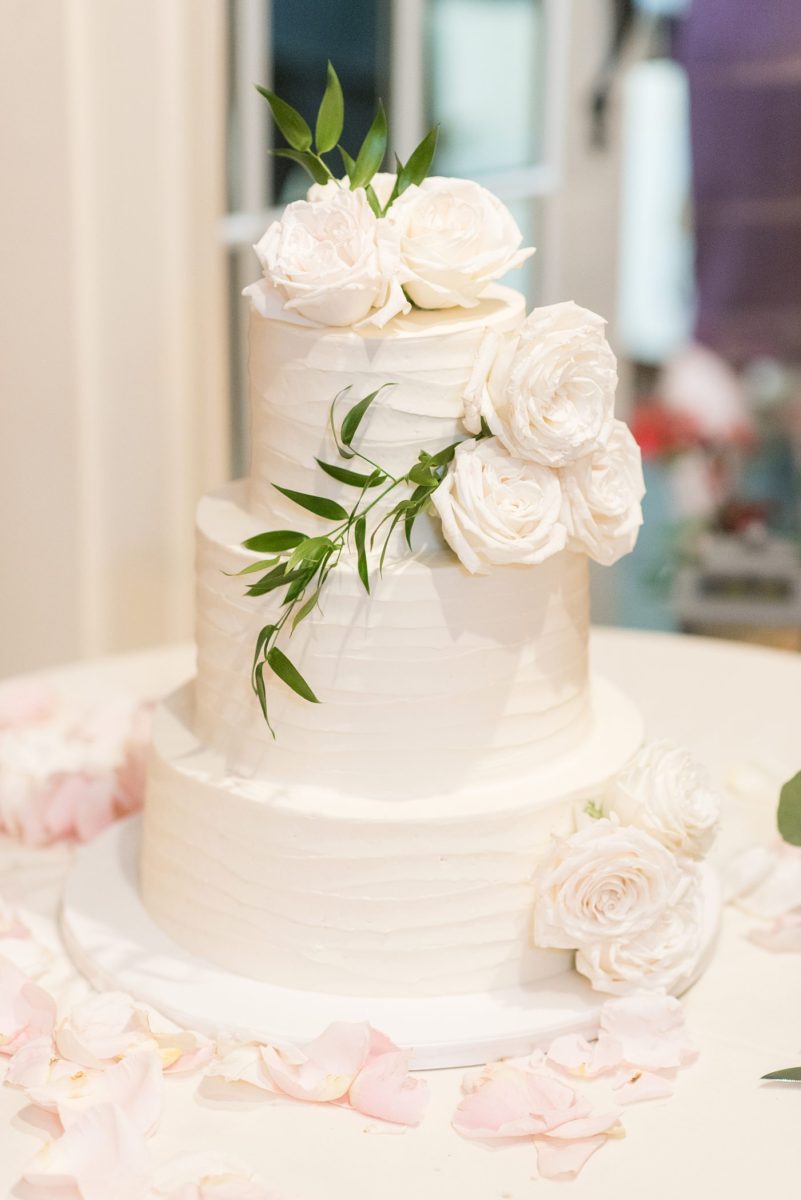 Indoor reception at Crabtree's Kittle House wedding after an outdoor ceremony in Chappaqua, New York. White buttercream tiered round cake with floral decorations by Mikkel Paige Photography for an autumn wedding. This venue in Westchester County is near the Hudson Valley and NYC. #mikkelpaige #hudsonvalleyweddings #crabtreeskittlehouse #fallwedding #westchestervenues #reception #weddingcake