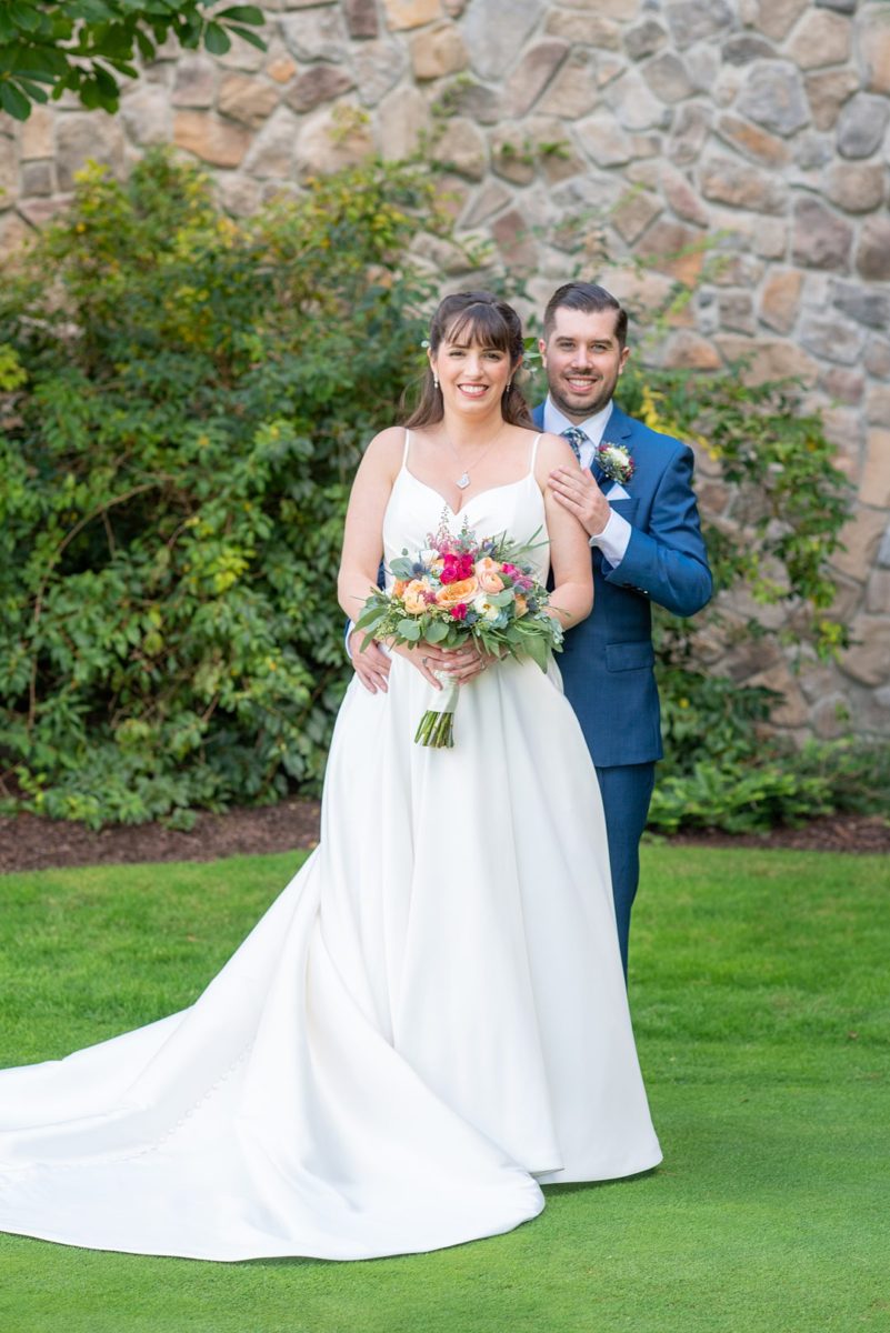 New Jersey wedding venue, Crystal Springs Resort, in Hamburg with an outdoor ceremony option and indoor reception. Photos by Mikkel Paige Photography. The bride wore a simple classic white dress with flowers in her hair and groom a blue suit and floral tie. #mikkelpaige #CrystalSprings #NJweddingvenues #NewJerseyWedding #NJweddingphotographer #brideandgroom