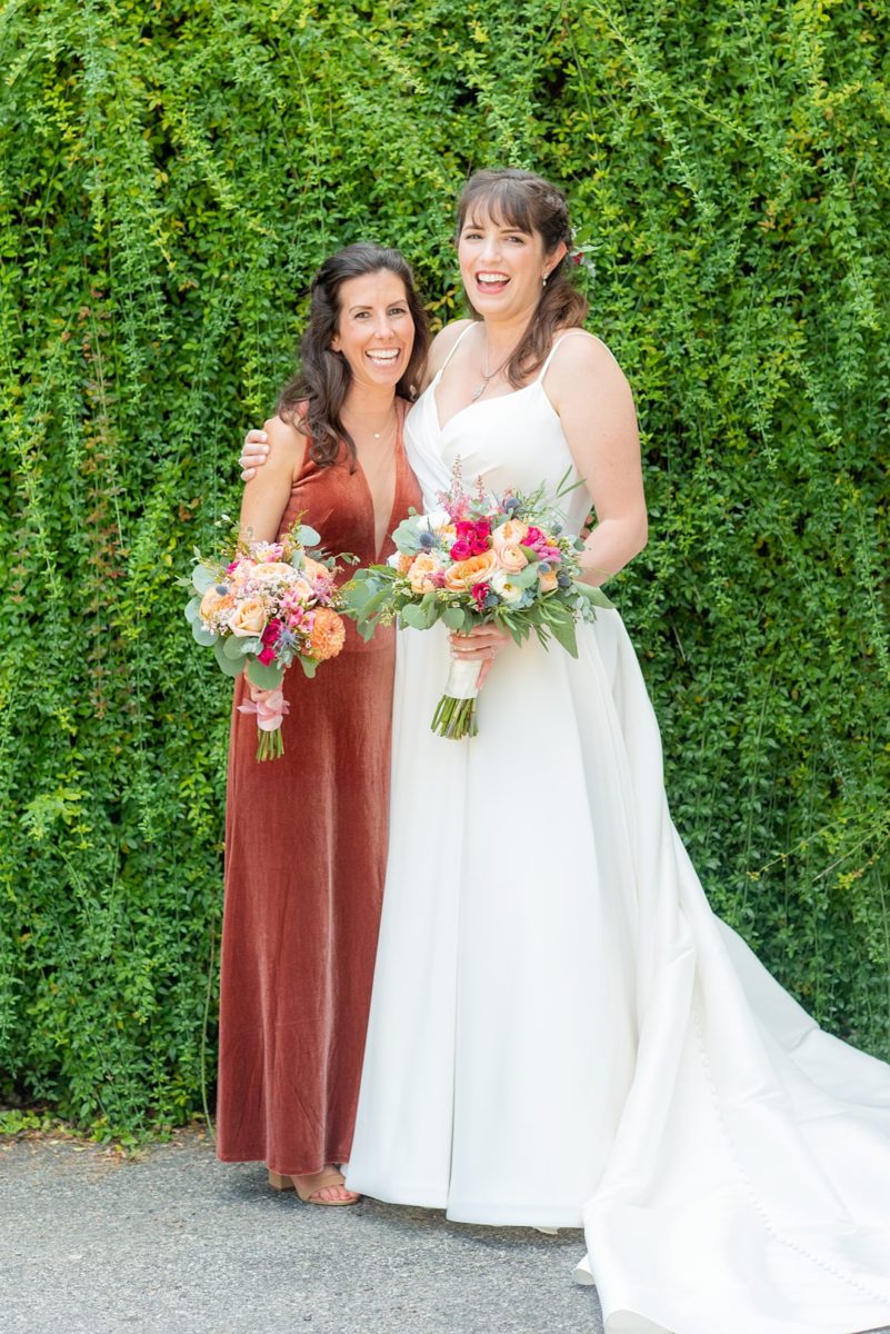 Photos at New Jersey wedding venue, Crystal Springs Resort, in Hamburg with an outdoor ceremony option and indoor reception, by Mikkel Paige Photography. The bride wore a white gown with spaghetti straps and maid of honor an orange rust colored velvet gown. They carried colorful bouquets. #mikkelpaige #CrystalSprings #NJweddingvenues #NewJerseyWedding #NJweddingphotographer #fallwedding #velvetdress #rustgown #weddingparty #bridalparty #smallweddingparty #smallbridalparty #colorfulbouquets